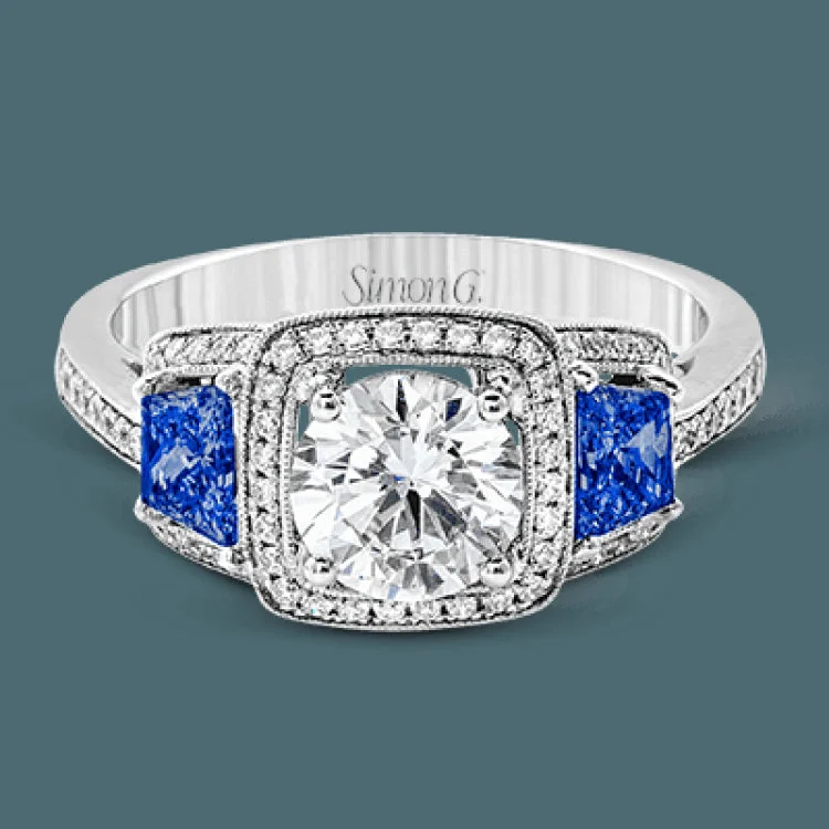 Featuring an elegant classic design, this white gold engagement ring is set with .23 ctw round cut white diamonds and side accents of .62 ctw trapezoid cut sapphires.