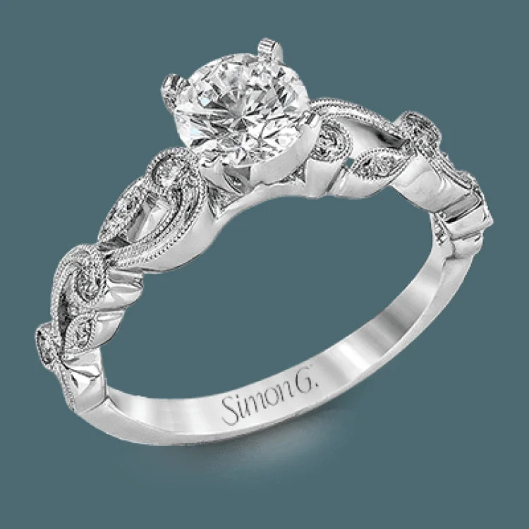 This delicate floral inspired white gold engagement ring and wedding band set is accentuated with .28 ctw shimmering round cut white diamonds.