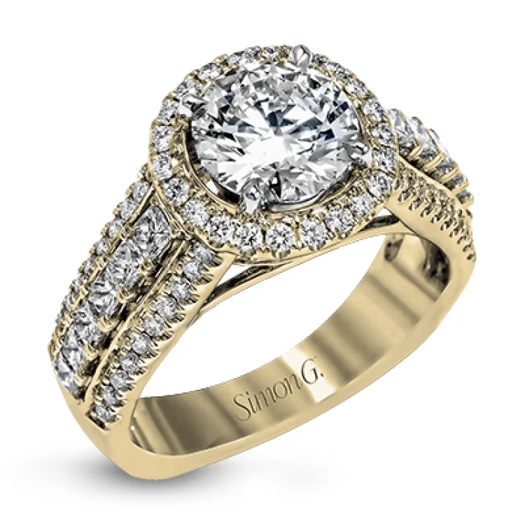 This bold engagement ring in 18K has a round halo, a cathedral design, and showcases PC diamonds 0.53 ctw. outlined by 2 rows of RD diamonds 0.46 ctw. on the shank, & accented with pave diamonds on the profile.