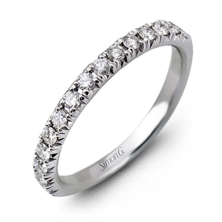 This elegant classic white gold halo engagement ring and band is set with .78 ctw of sparkling round cut white diamonds.