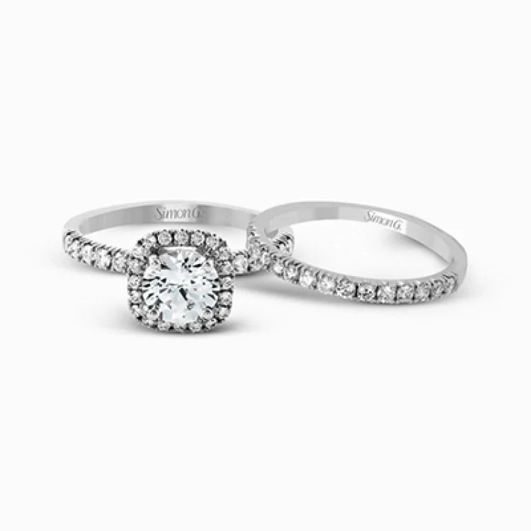 This elegant classic white gold halo engagement ring and band is set with .78 ctw of sparkling round cut white diamonds.