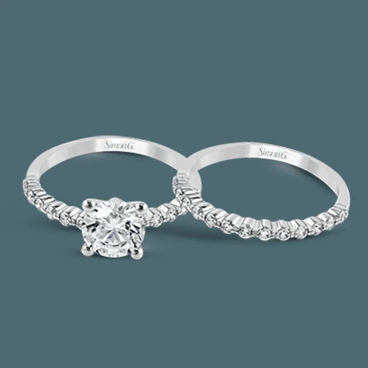 Featuring a charming classic design, this white gold engagement set is accented by .48 ctw of glistening round cut white diamonds.