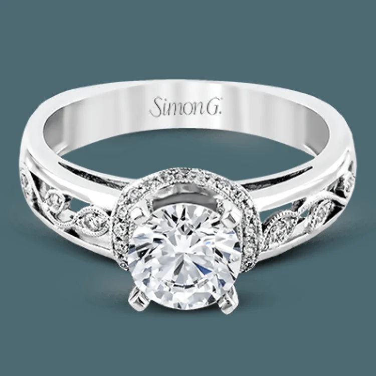 Set with delicate floral patterns, this classic white gold engagement ring is highlighted with .12 ctw round cut white diamonds.