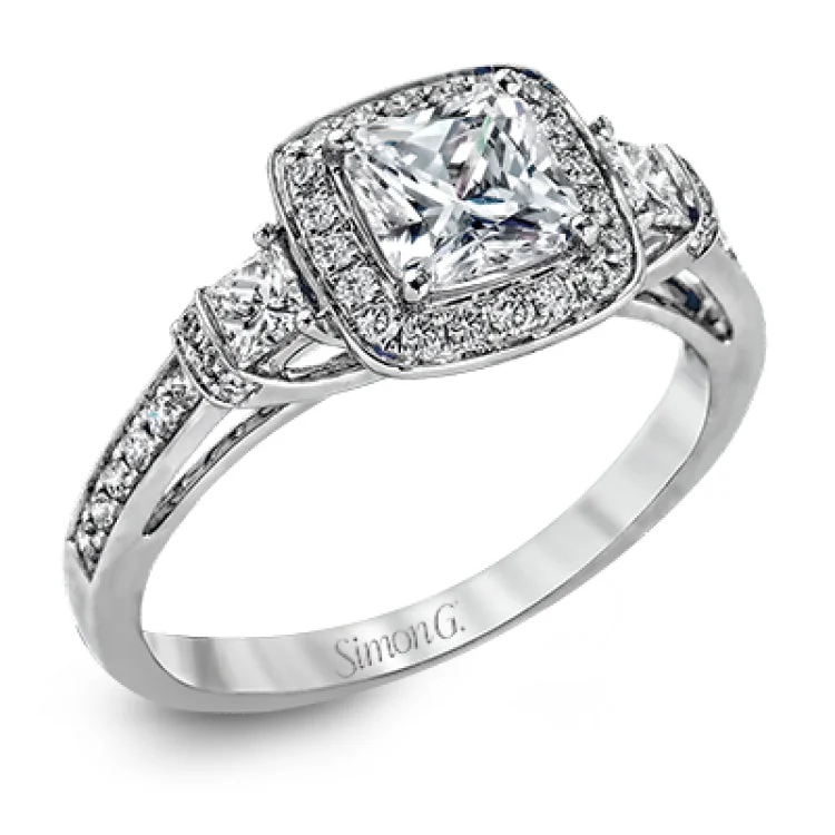 Featuring an intricate design, this white gold engagement ring is emphasized by .26 ctw of round cut white diamonds and .23 ctw of shimmering princess cut white diamonds.