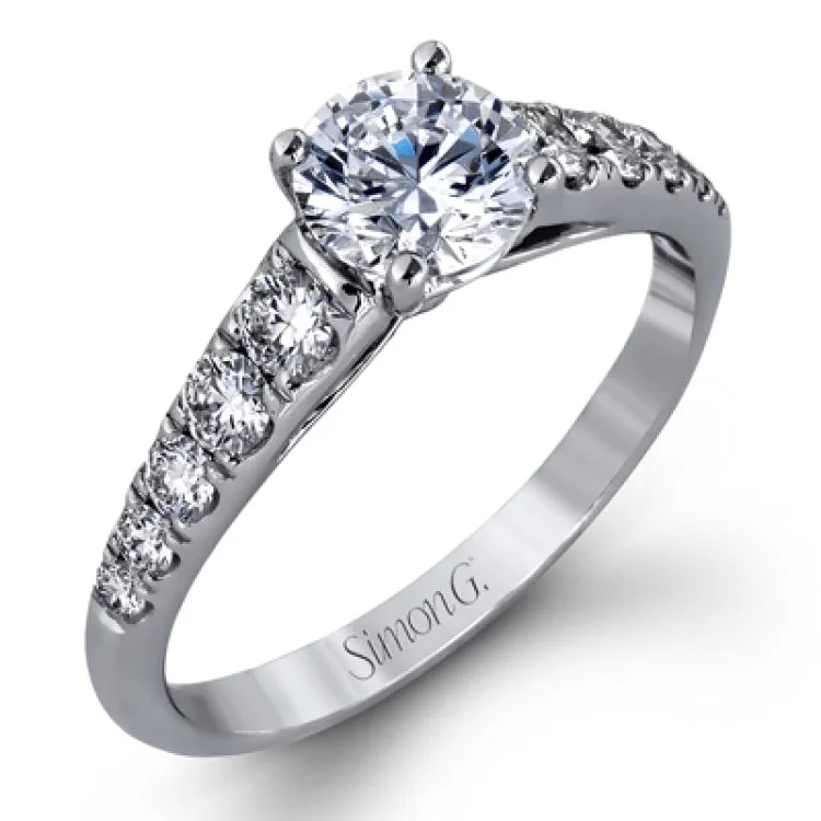 Elevating a classic design with modern elements, this exquisite white gold engagement ring and band are emphasized by .77 ctw of sparkling round cut white diamonds.