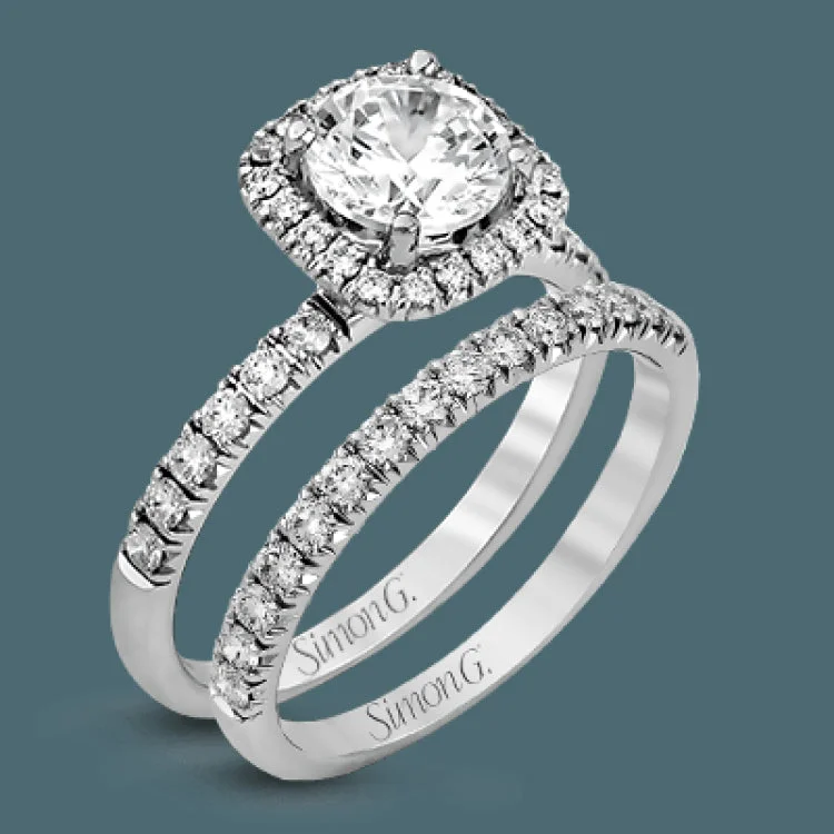 This elegant classic white gold halo engagement ring and band is set with .78 ctw of sparkling round cut white diamonds.