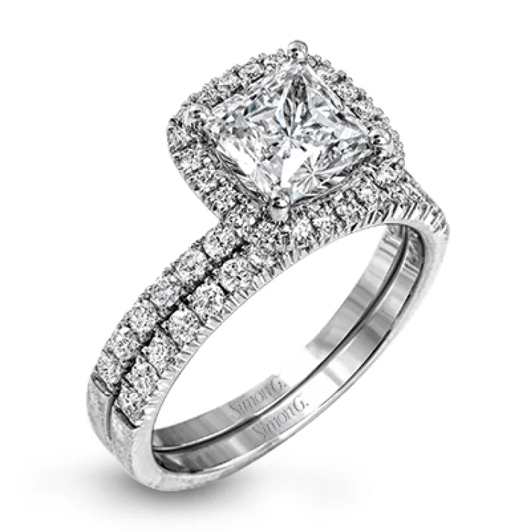 This elegant classic white gold halo engagement ring and band is set with .78 ctw of sparkling round cut white diamonds.