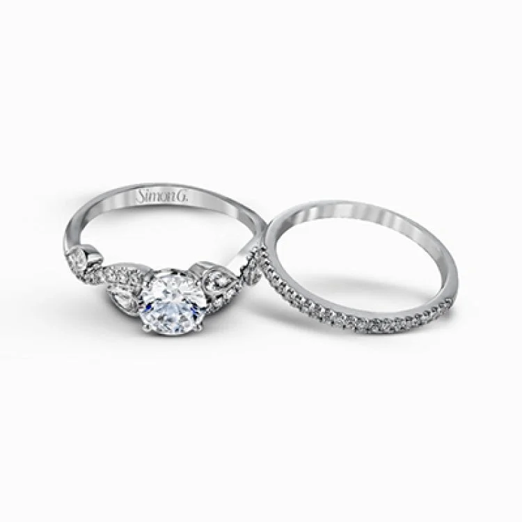 Featuring a distinctively romantic design, this white gold engagement ring and band are set with .22 ctw of round cut white diamonds, .09 ctw of marquise cut diamonds, and .13 ctw pear-shaped diamonds.