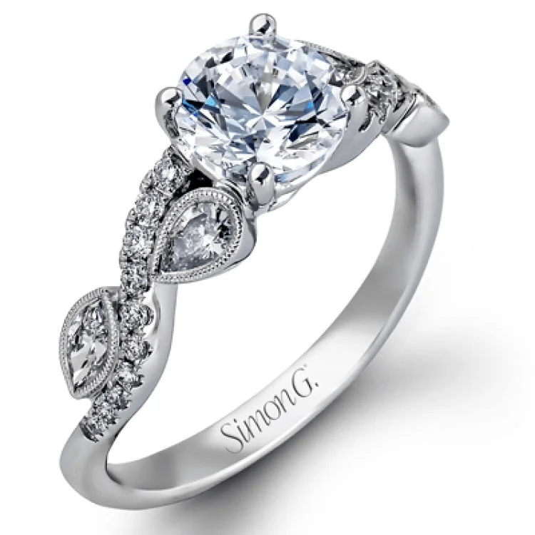 Featuring a distinctively romantic design, this white gold engagement ring and band are set with .22 ctw of round cut white diamonds, .09 ctw of marquise cut diamonds, and .13 ctw pear-shaped diamonds.