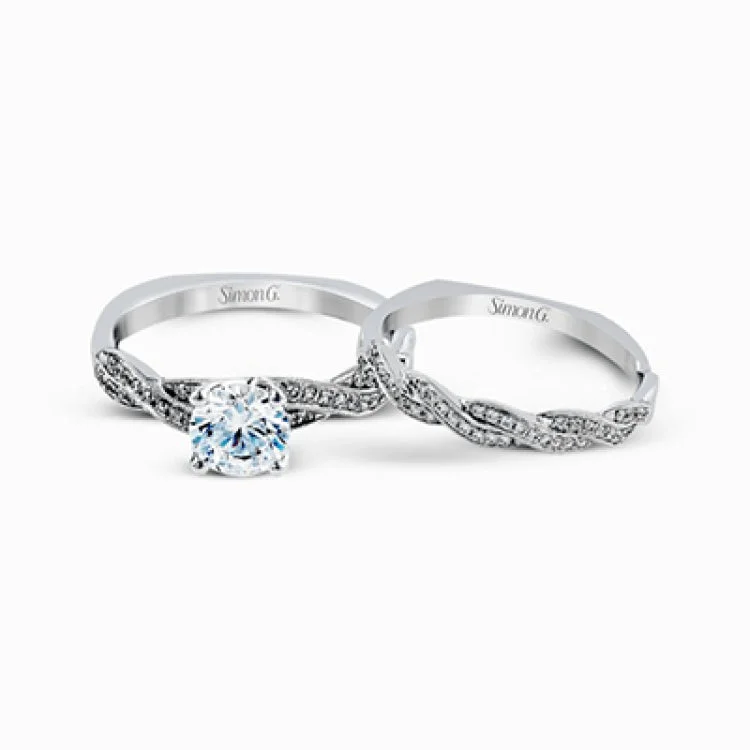 Featuring a modern design, this elegant white gold engagement ring and wedding band set are accentuated by .22 ctw of shimmering round cut white diamonds.