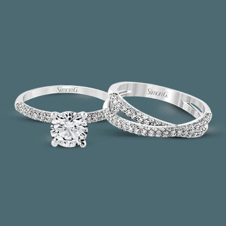 This impressive contemporary white gold engagement ring and wedding band set are emphasized by 1.00 ctw of dazzling round cut white diamonds.