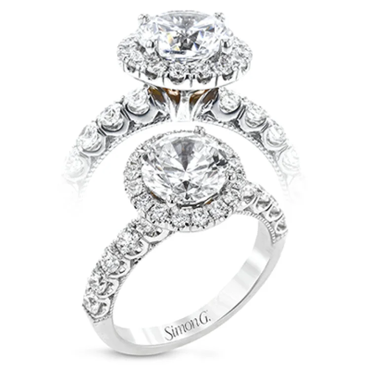 This stunThis stunning halo engagement ring in 18K white gold takes a 2.0 ct center, and has 0.92 ctw of RD brilliant diamonds on the sides & the halo combined.